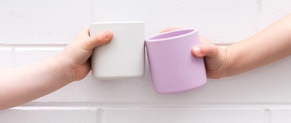 babies doing cheers action with silicone mugs